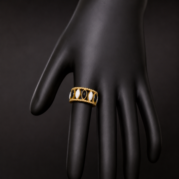 Gold black and white stone ring on downward black hand