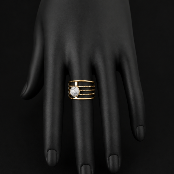 Gold white stone layered ring on downward black hand