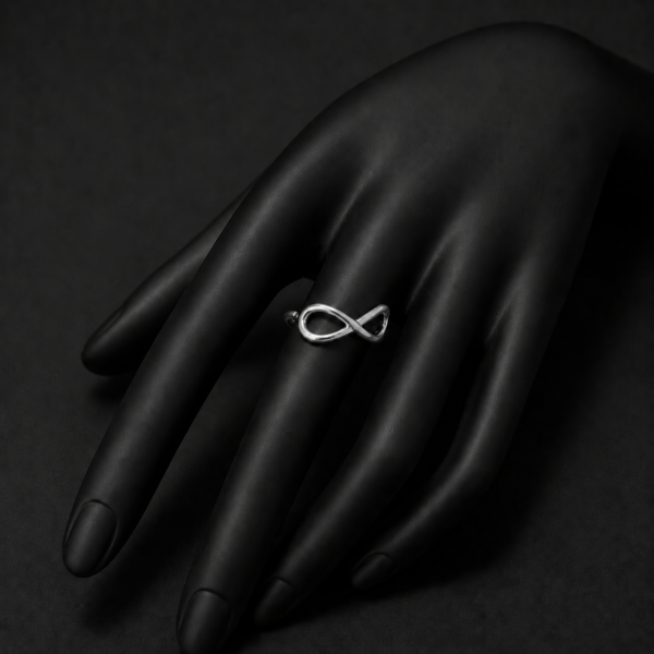 Silver infinity ring on black hand mannequin