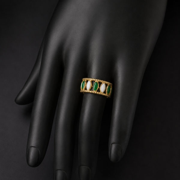 Gold green and white stone ring on downward black hand