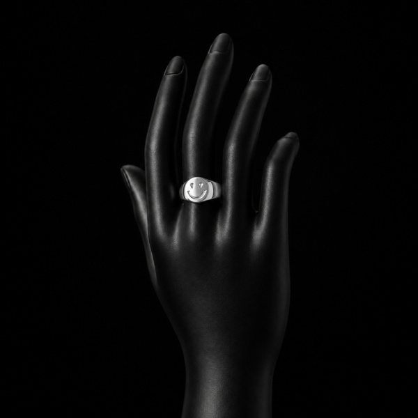Silver smiley face signet ring on upright black hand mannequin