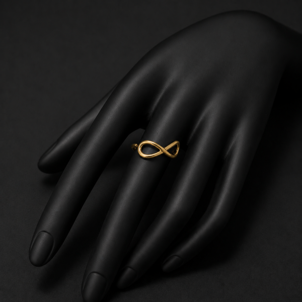 Gold infinity ring on black hand mannequin