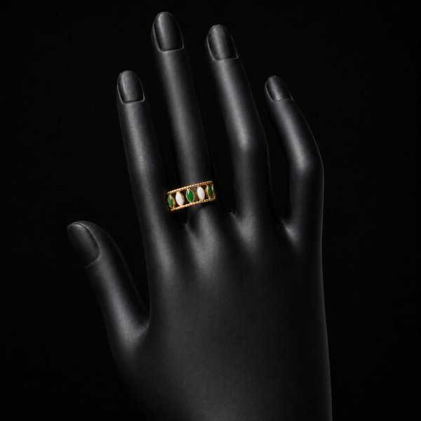 Gold green and white stone ring on upright black hand
