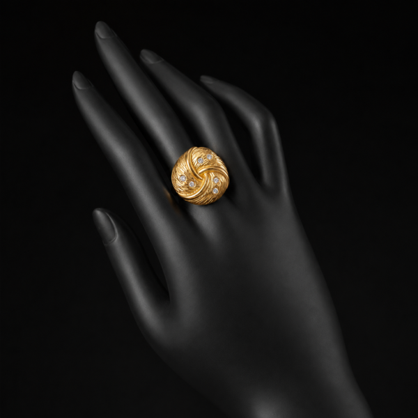 Gold swirl statement ring on black hand mannequin