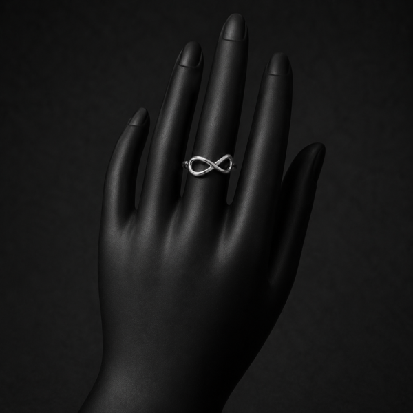 Silver infinity ring on upright black hand display