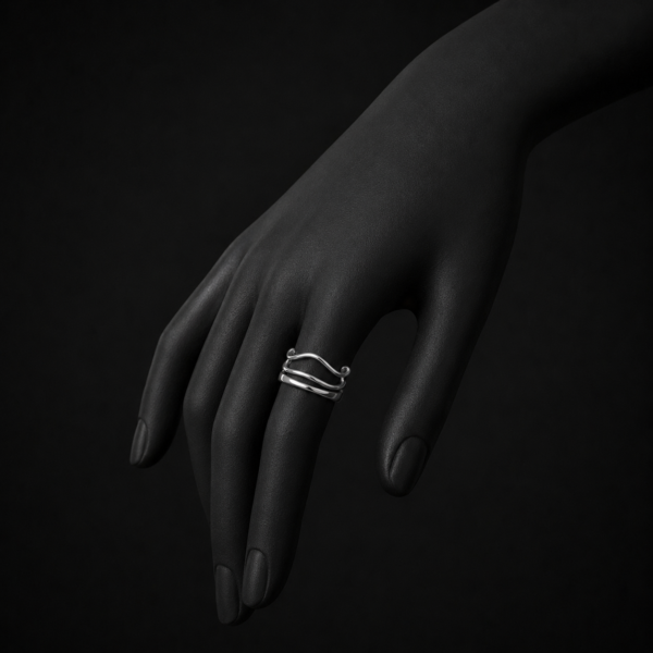 Silver wave ring on black mannequin hand side angle