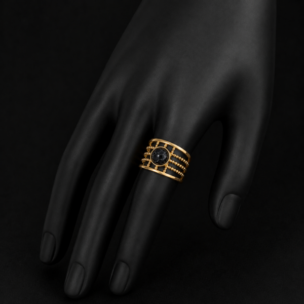 Gold black stone layered ring on downward black hand