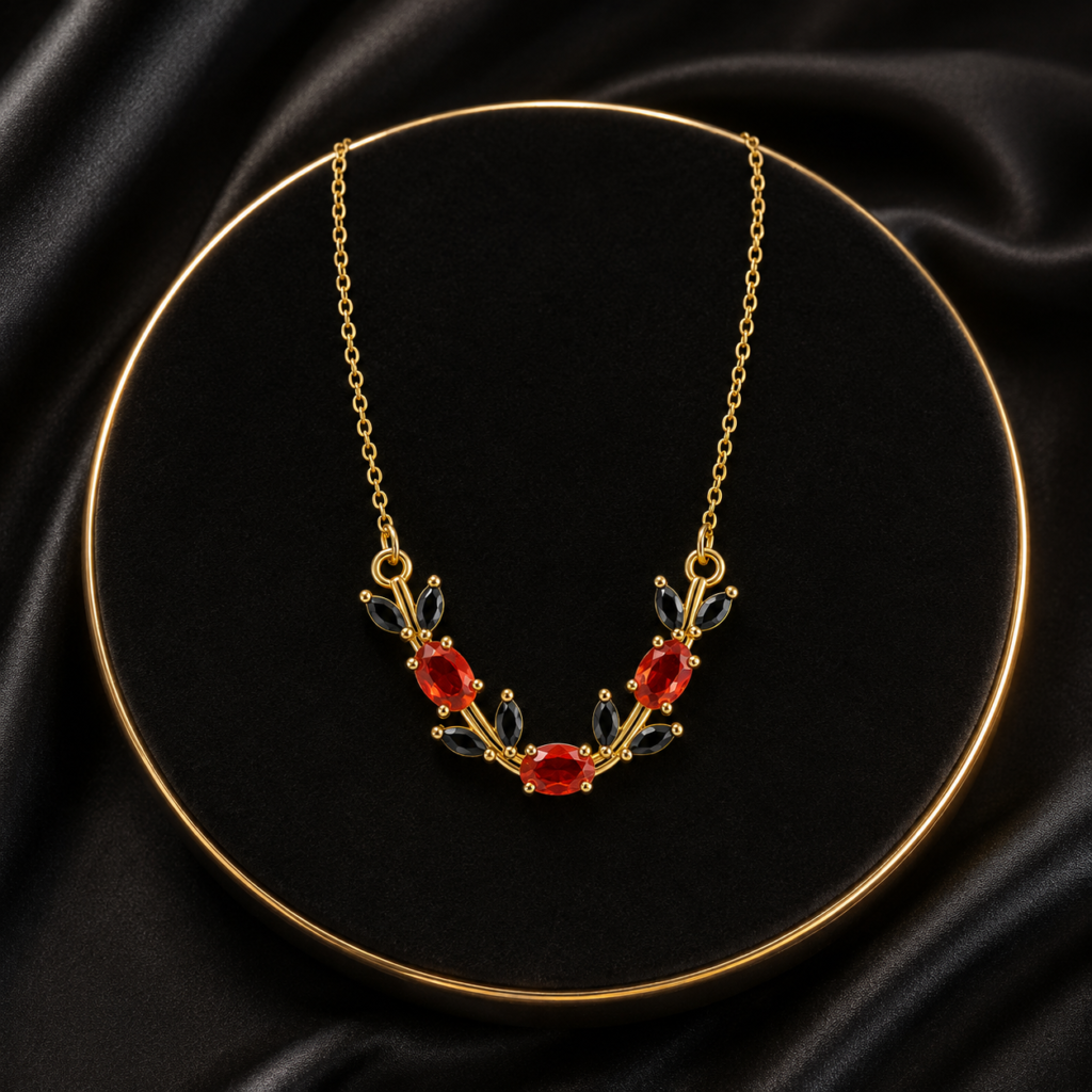 Red and green floral leaf crystal-style necklace displayed on black fabric