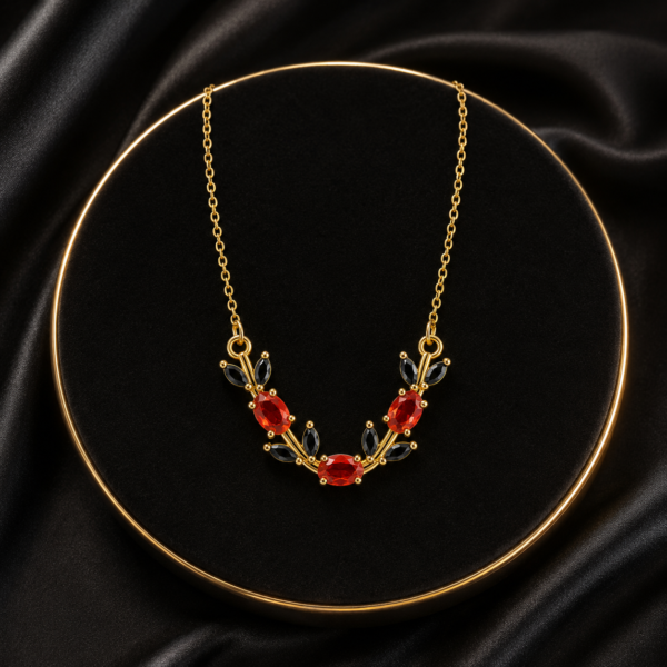 Red and green floral leaf crystal-style necklace displayed on black fabric