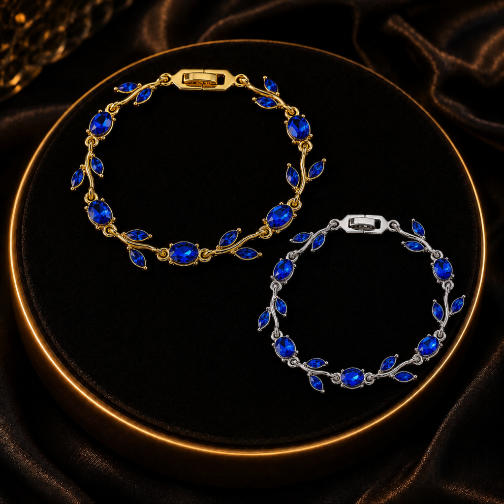 Two blue leaf crystal-style bracelets arranged on black fabric