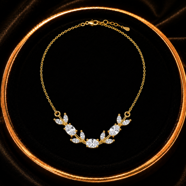 White and clear leaf crystal-style necklace displayed on a black tray