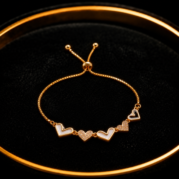 Gold-tone heart slider bracelet with crystal heart detail on a black tray