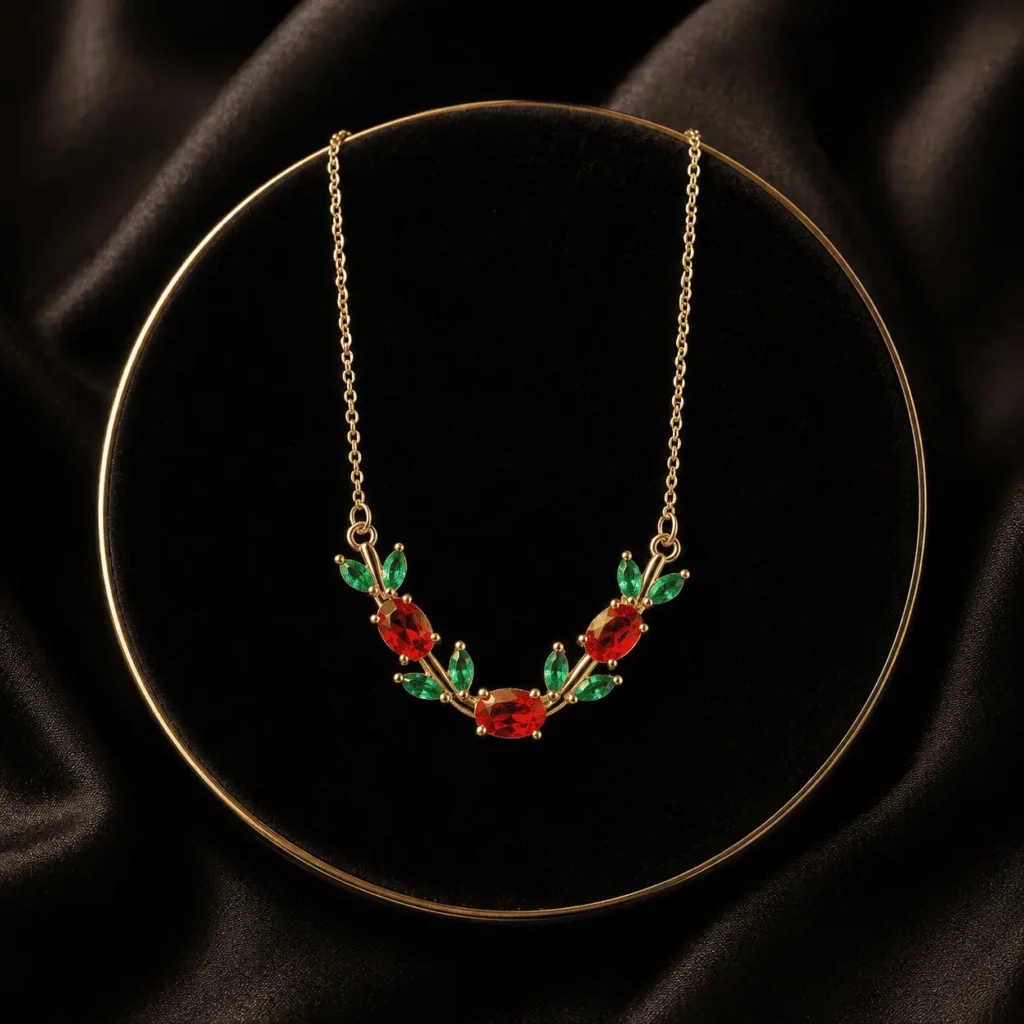 Red and green floral leaf crystal-style necklace arranged on black fabric