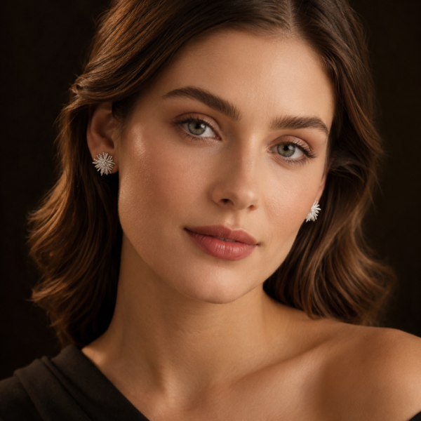 Model wearing silver-tone starburst stud earrings