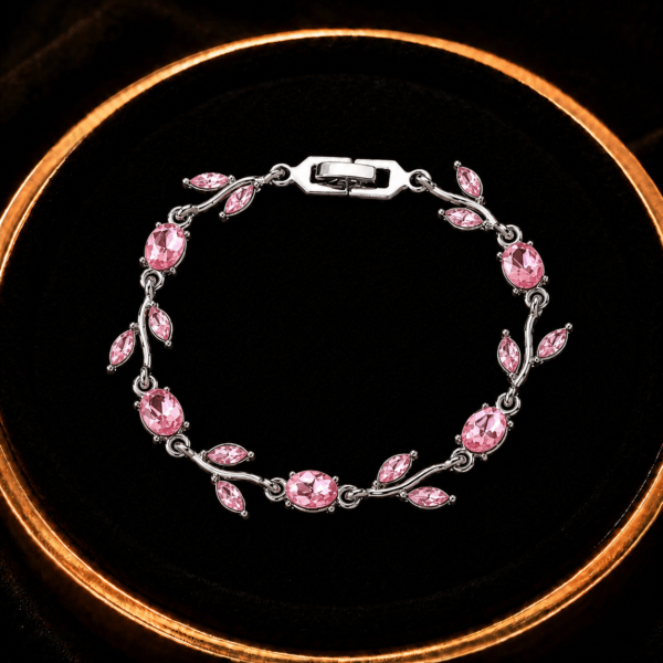 Pink leaf crystal-style bracelet displayed on a black jewelry tray
