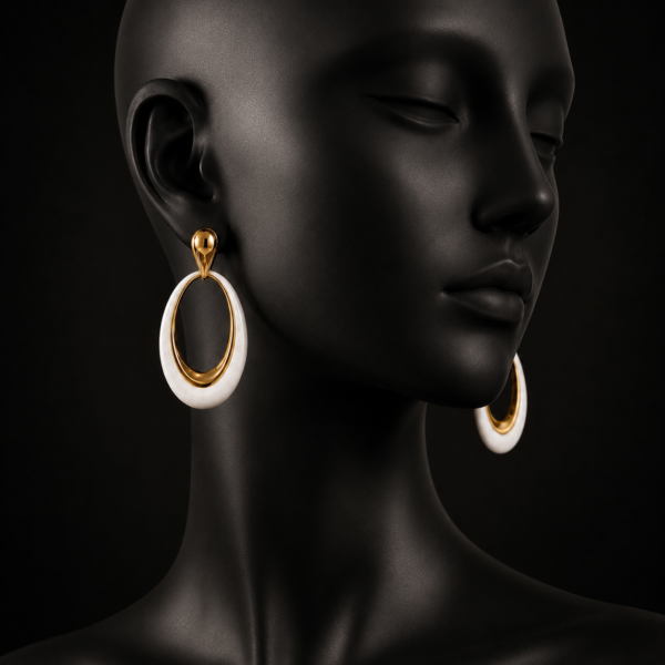 White oval drop earrings with gold-tone accents shown close up on a model