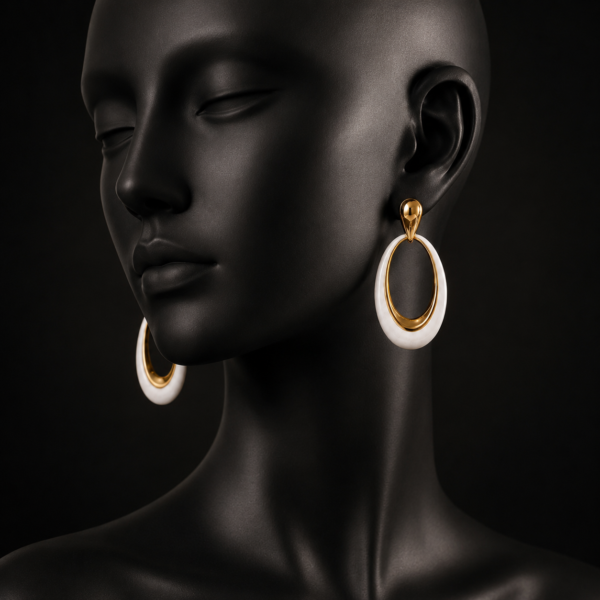 White oval drop earrings with gold-tone accents worn by a model
